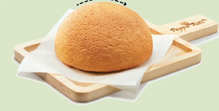 A PappaRoti signature bun served warm on its wooden paddle